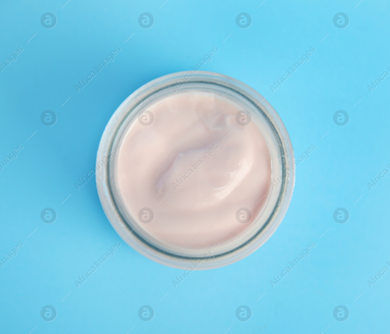 Photo of Tasty organic yogurt on light blue background, top view