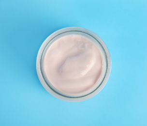 Photo of Tasty organic yogurt on light blue background, top view