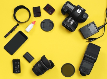 Flat lay composition with professional photographer equipment and space for text on color background