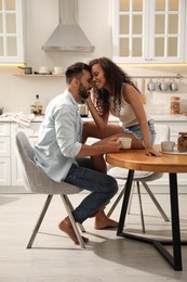 Photo of Lovely couple enjoying time together at table in kitchen