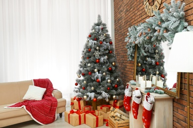 Stylish interior with beautiful Christmas tree and decorative fireplace