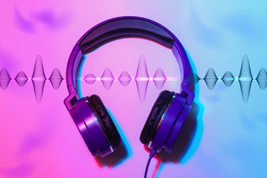 Image of Modern headphones with illustration of dynamic sound waves on color background, top view