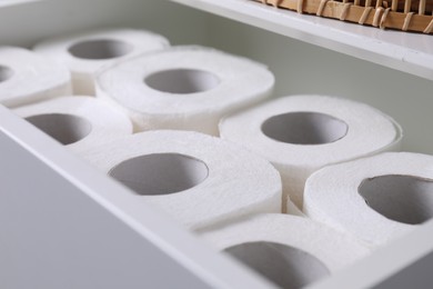 Photo of Many toilet paper rolls in white drawer indoors, closeup