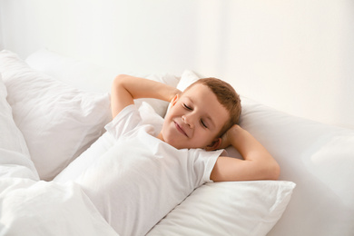 Cute little boy sleeping in bed at home