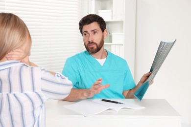 Photo of Doctor with neck MRI scan consulting patient in hospital