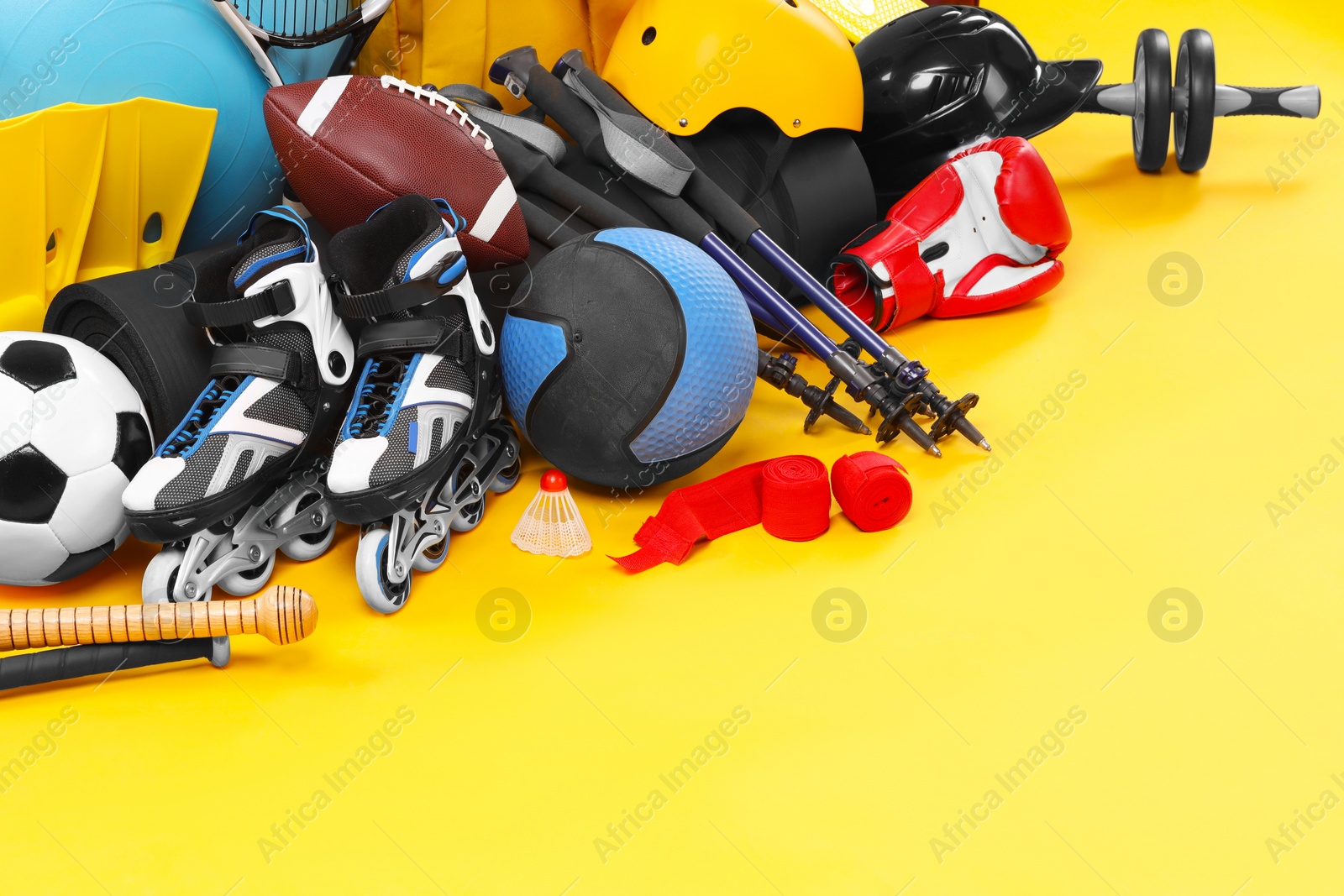 Photo of Many different sports equipment on yellow background, space for text