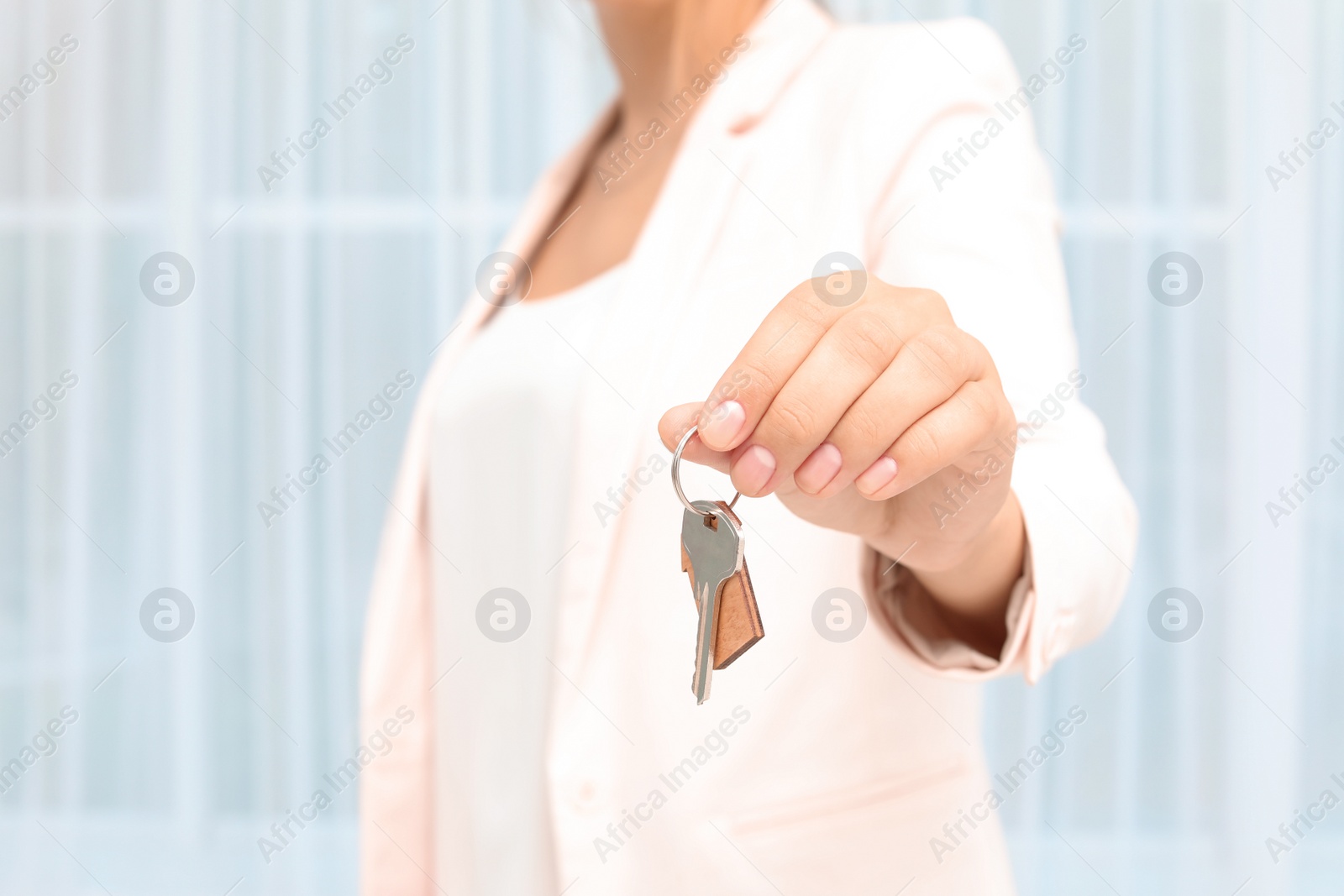 Photo of Real estate agent with key on blurred background