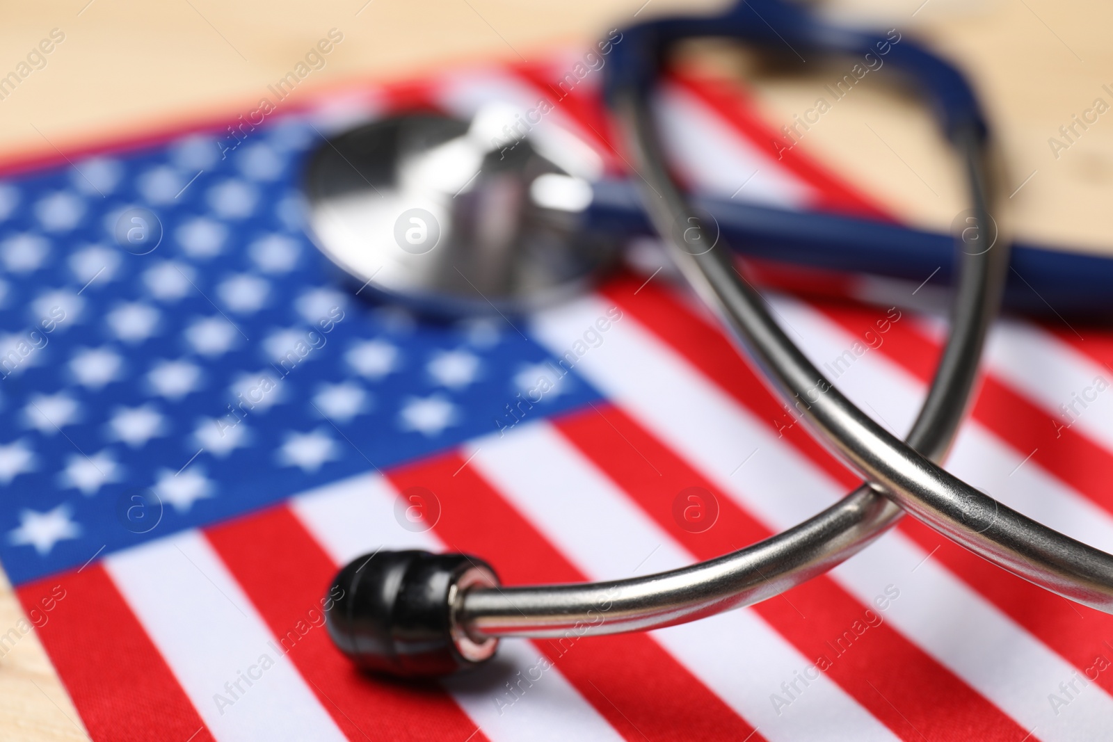 Photo of Stethoscope and USA flag on table, closeup. Health care concept