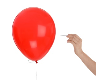 Photo of Woman piercing red balloon on white background