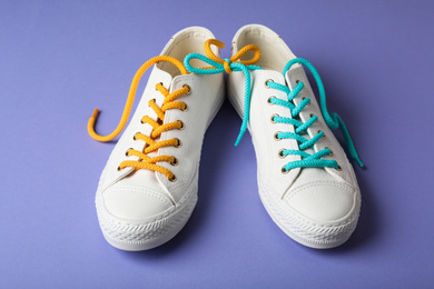 Shoes tied together on lilac background. April Fool's Day