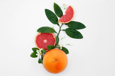 Photo of Fresh ripe grapefruits and green leaves on white background, flat lay
