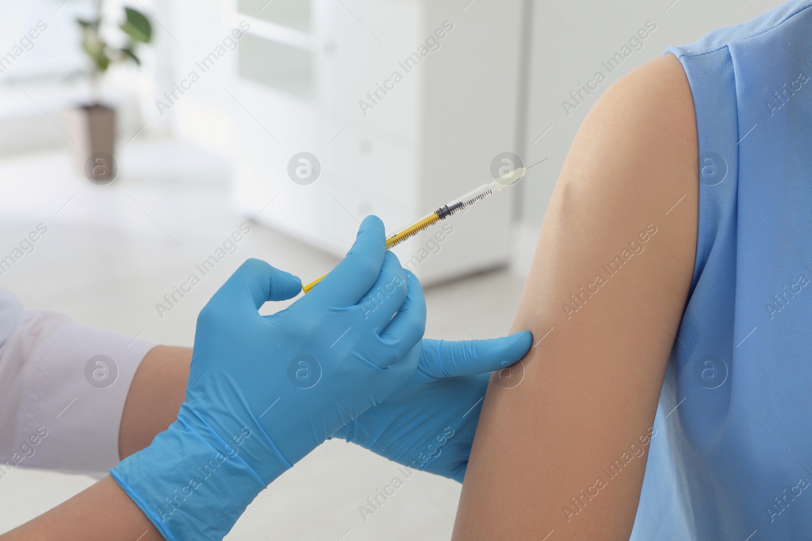 Photo of Doctor giving injection to woman in hospital, closeup. Immunization concept