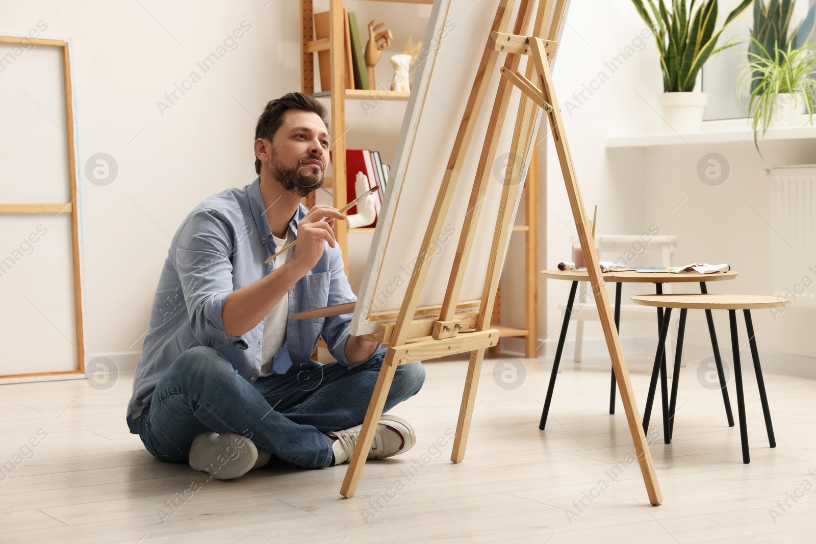 Photo of Handsome man painting in studio. Creative hobby