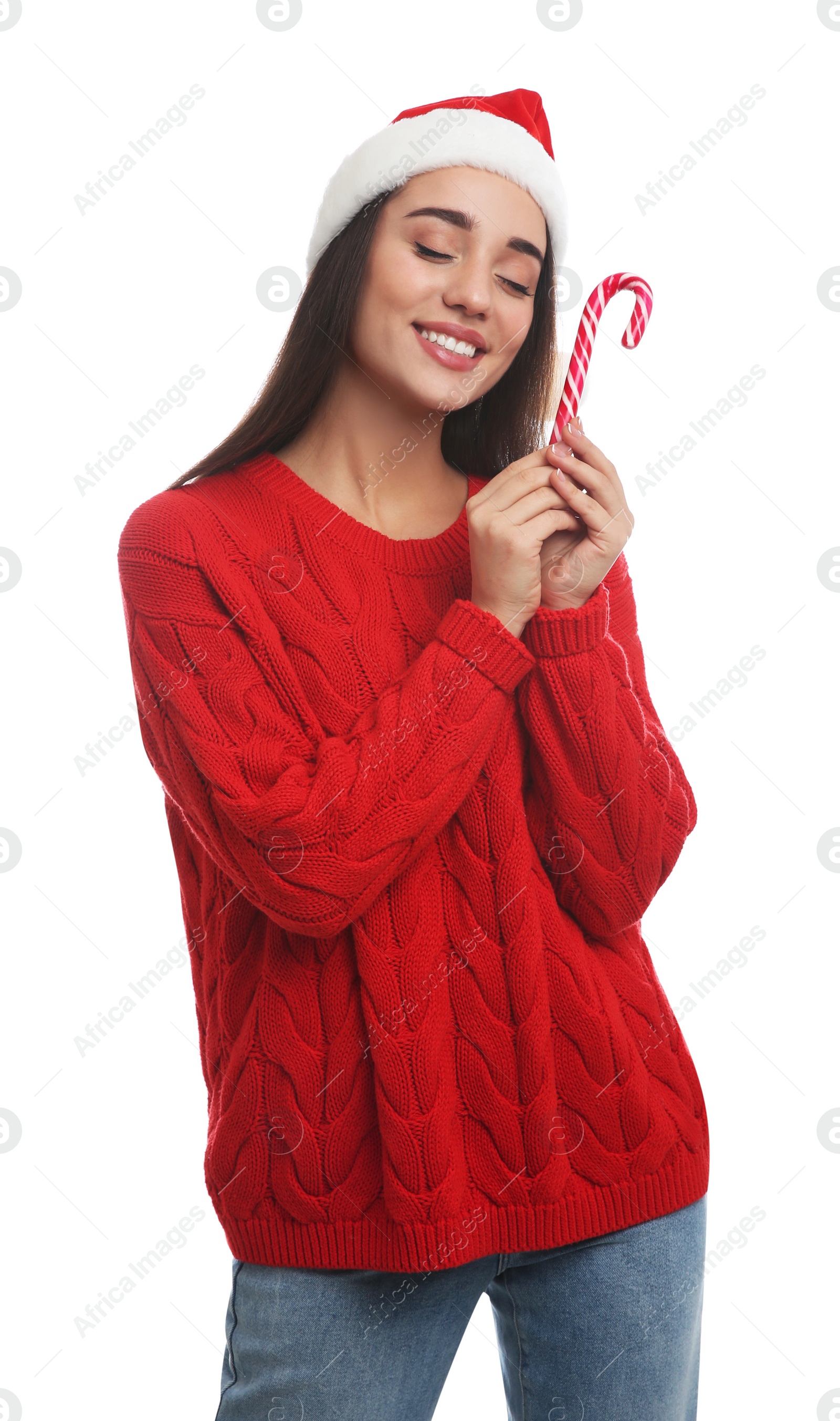 Photo of Young woman in red sweater and Santa hat holding candy cane on white background. Celebrating Christmas