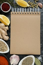 Photo of Blank recipe book and different ingredients on black textured table, flat lay. Space for text