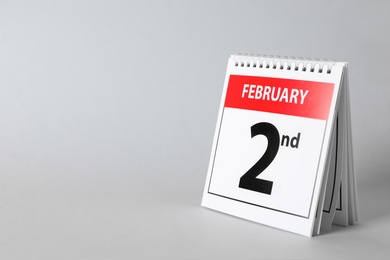 Photo of Calendar with date February 2nd on light background, space for text. Groundhog day