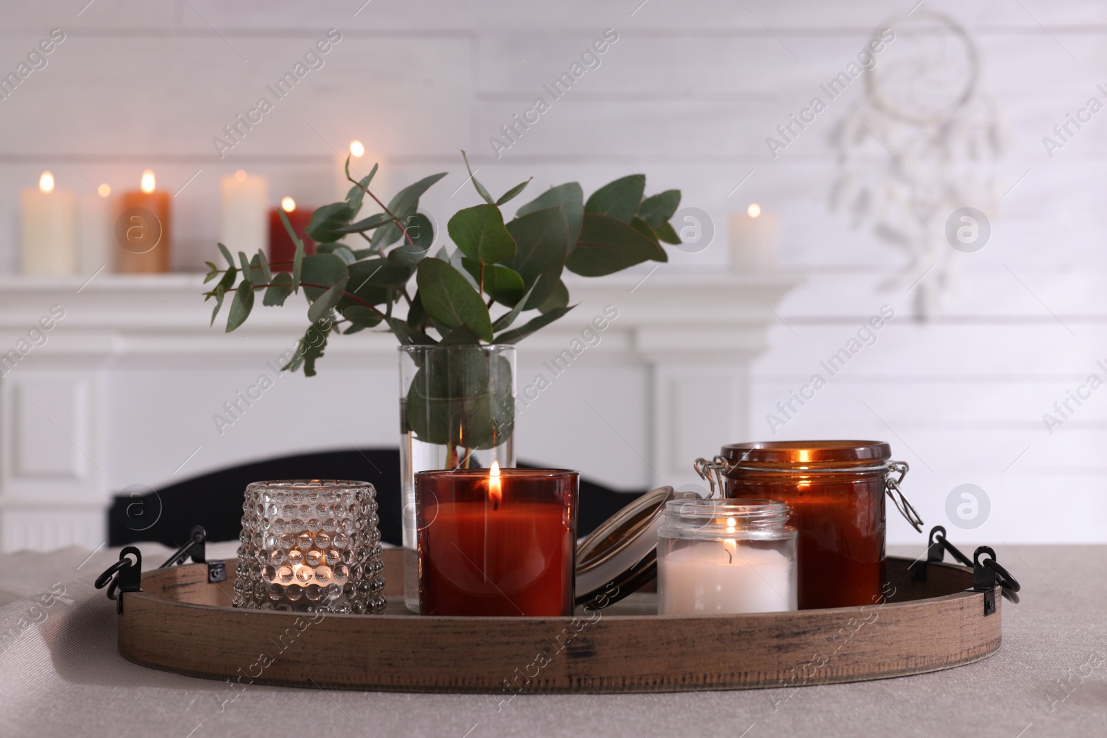 Photo of Tray with beautiful burning candles and vase on table indoors