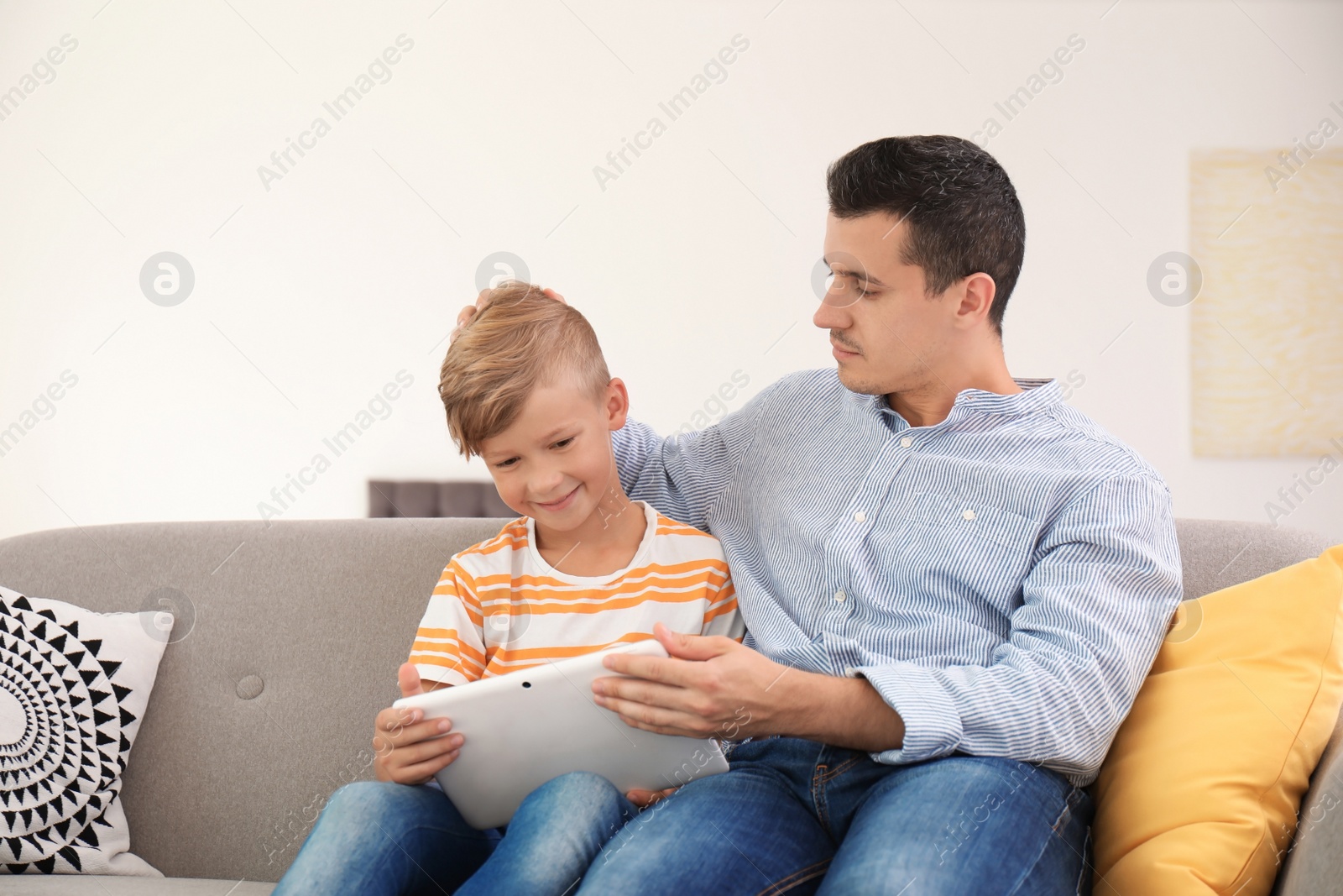 Photo of Father with child using tablet at home. Happy family