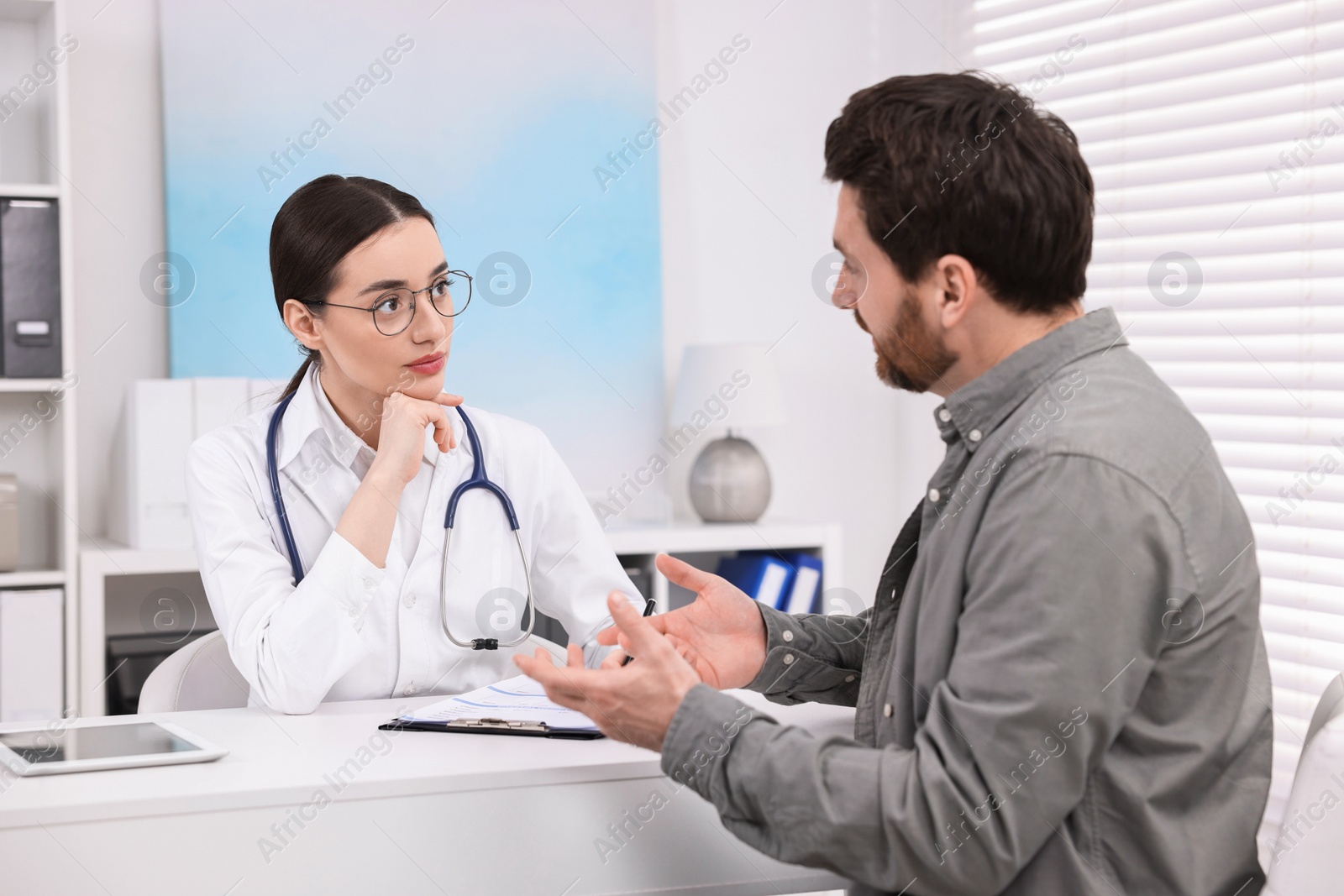 Photo of Doctor consulting patient during appointment in clinic