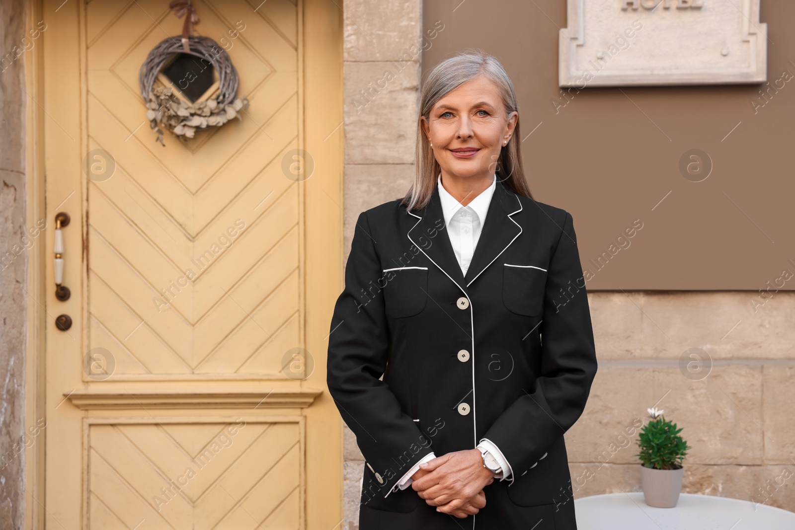 Photo of Portrait of smiling business owner near her hotel outdoors, space for text