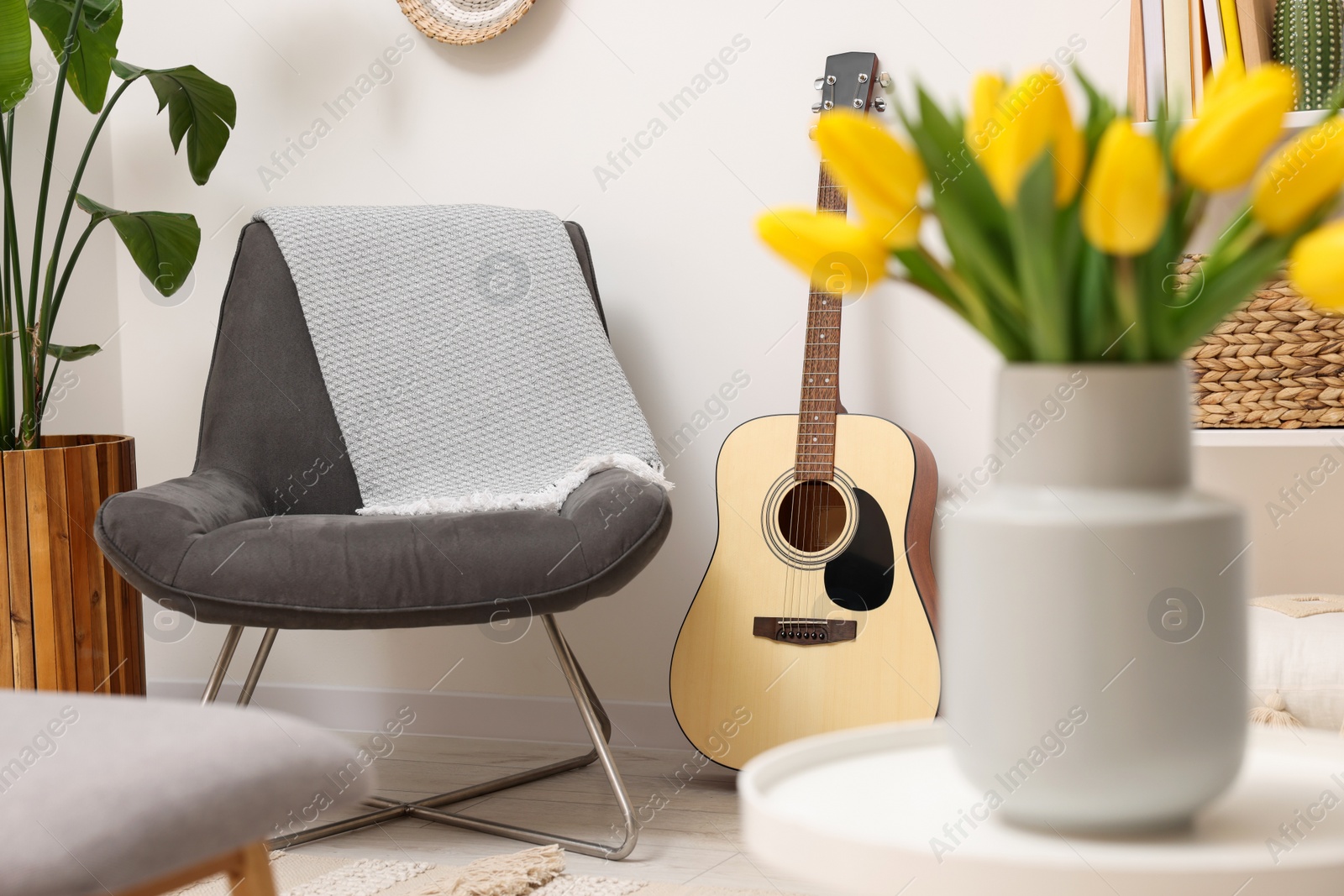 Photo of Spring interior. Bouquet of beautiful yellow tulips on white table in living room