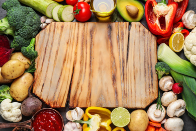 Photo of Fresh products and wooden board with space for text, flat lay. Healthy cooking
