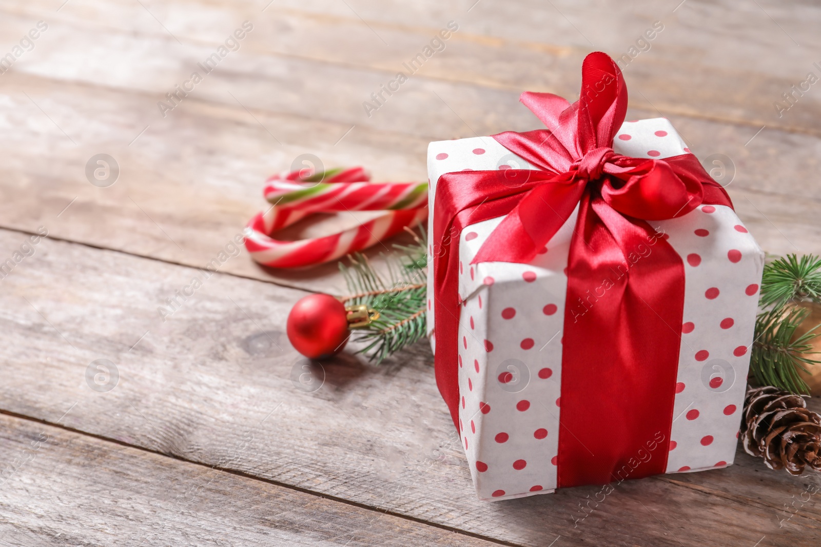 Photo of Beautiful composition with gift box and Christmas decorations on wooden table