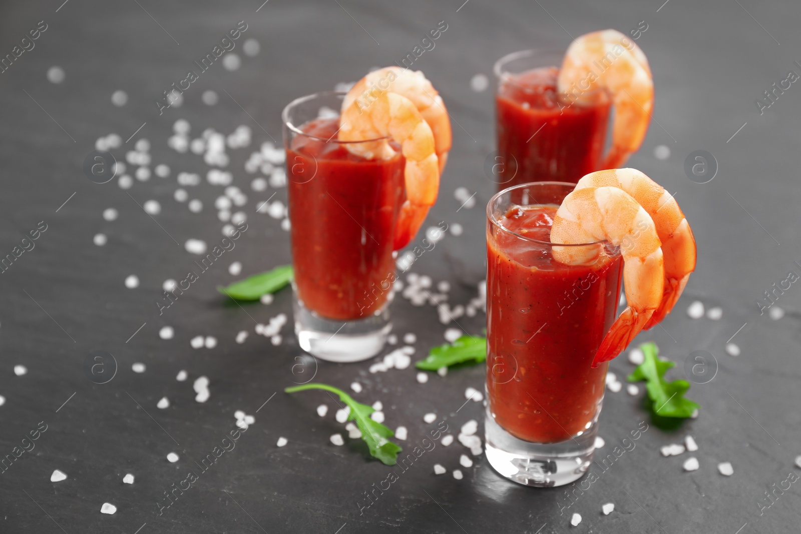 Photo of Delicious shrimp cocktail with tomato sauce served on black table