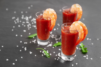 Photo of Delicious shrimp cocktail with tomato sauce served on black table