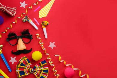 Photo of Flat lay composition with clown's accessories on red background. Space for text