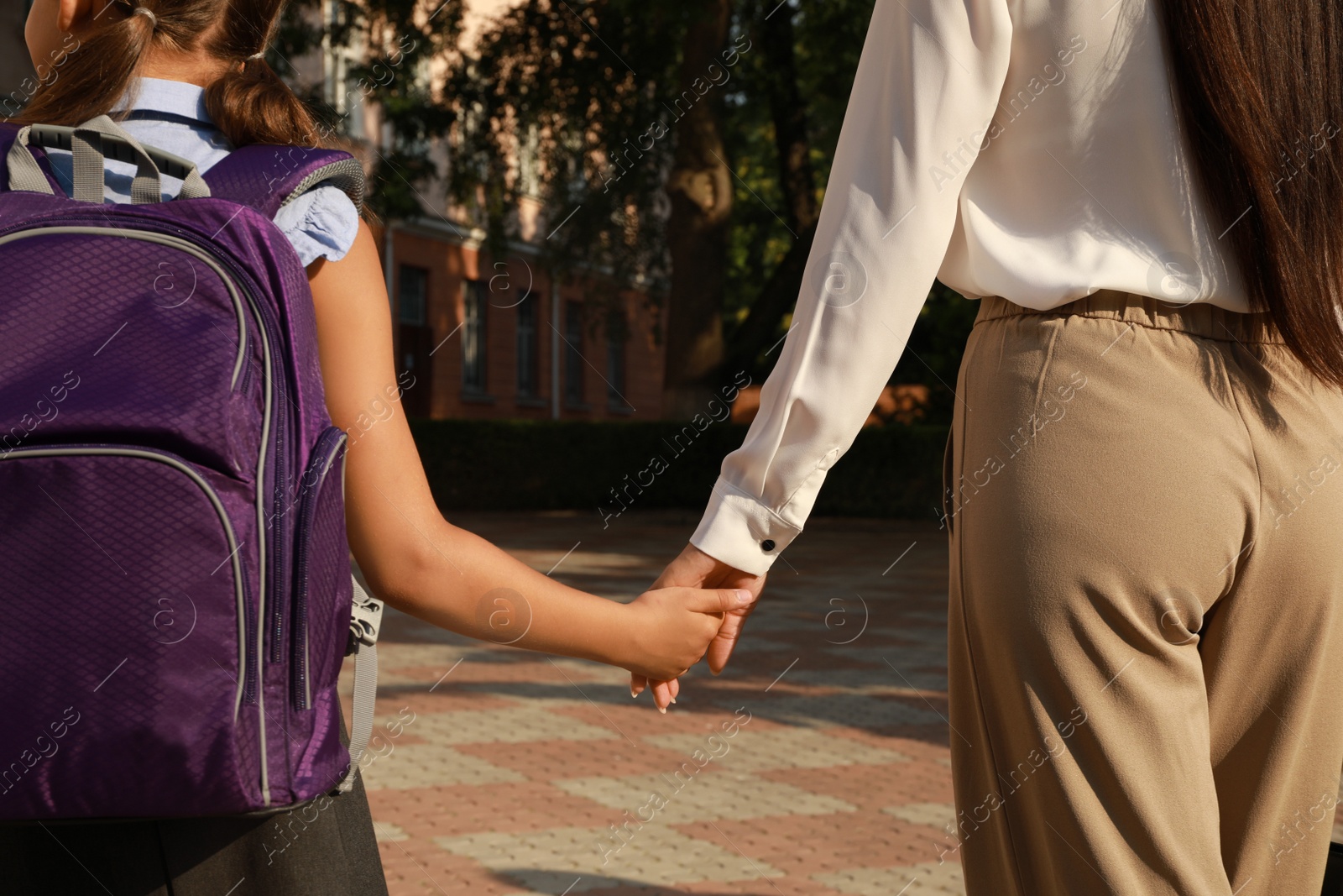 Photo of Mother taking her daughter to school, closeup