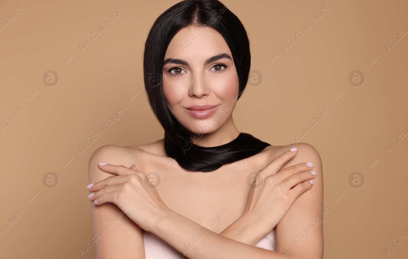 Photo of Portrait of beautiful young woman with healthy strong hair on beige background