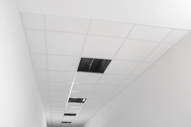 Low angle view on PVC tiles. Installing ceiling lighting