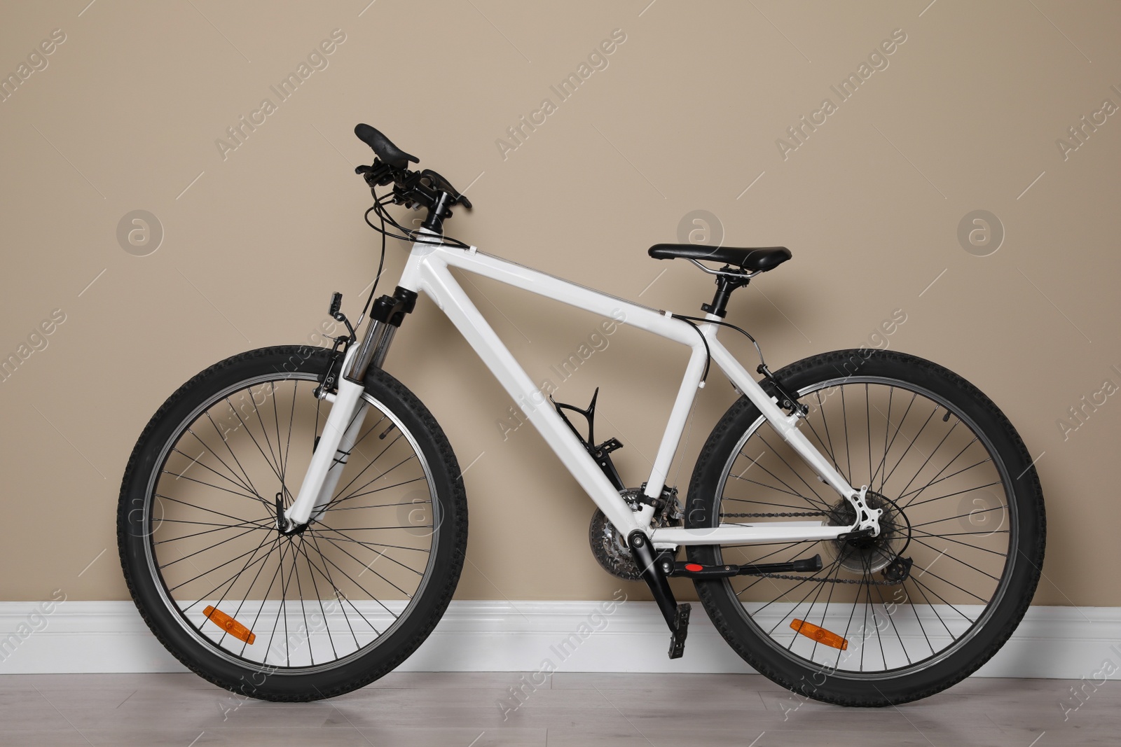 Photo of Modern sport mountain bike near beige wall