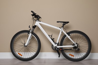 Modern sport mountain bike near beige wall