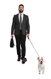 Smiling businessman walking with dog on white background