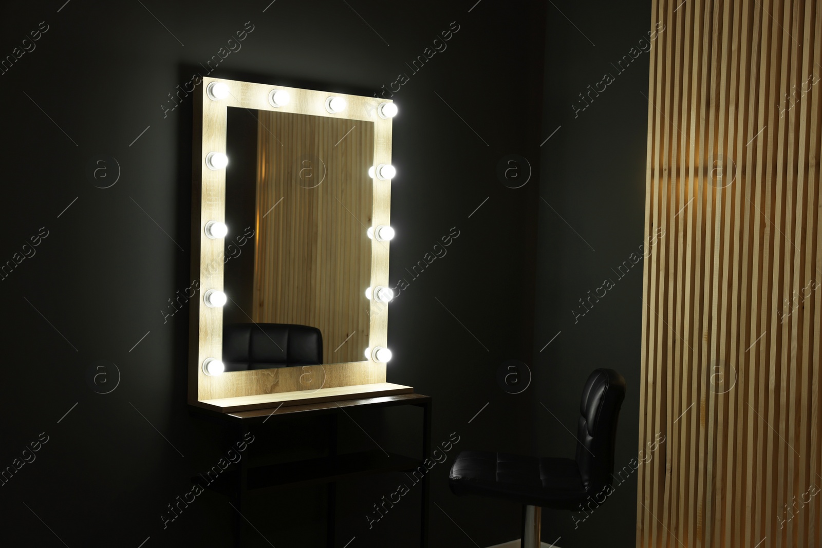 Photo of Beautiful mirror with light bulbs and chair in makeup room