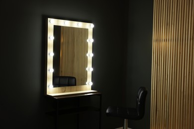 Photo of Beautiful mirror with light bulbs and chair in makeup room