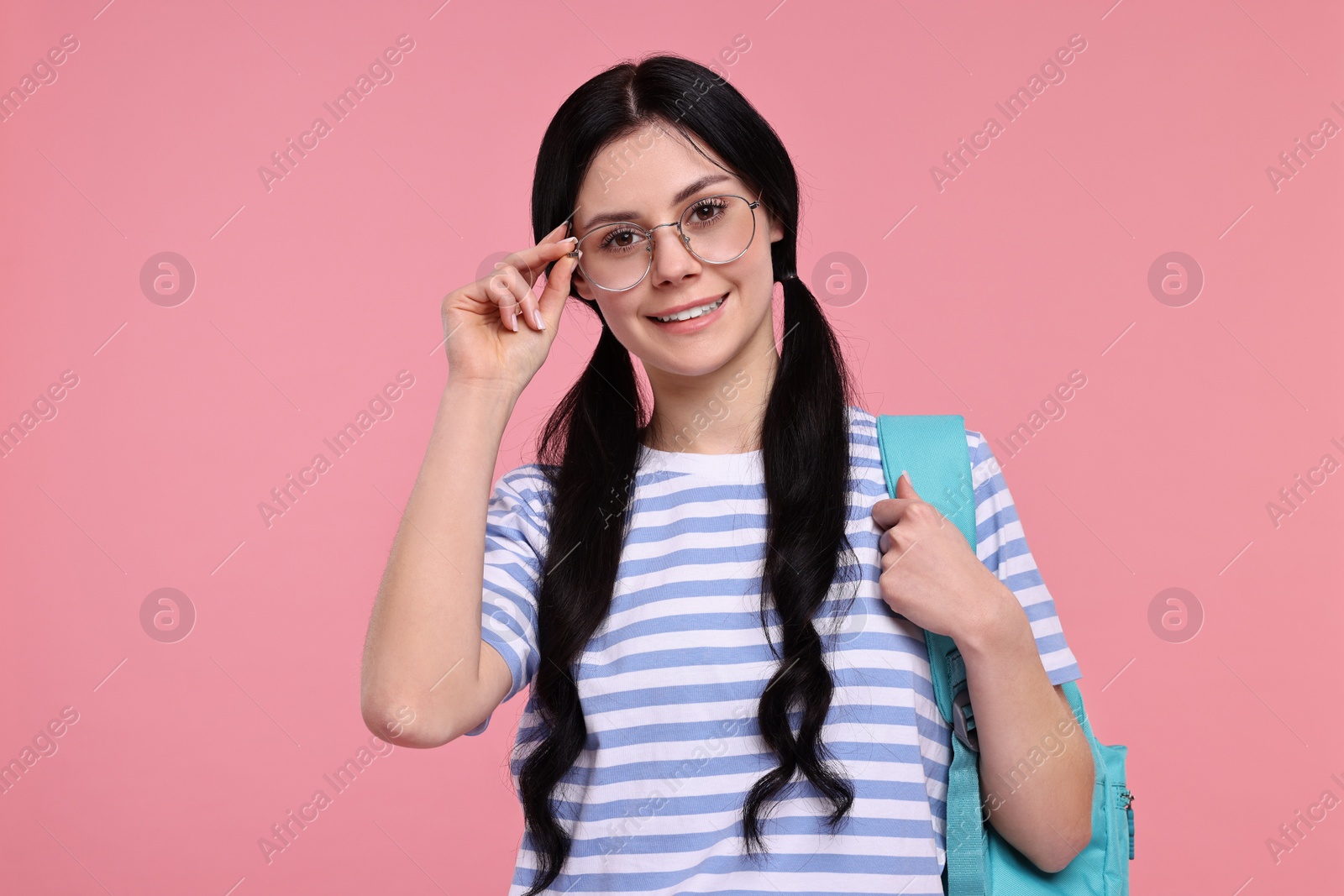 Photo of Smiling student with backpack on pink background