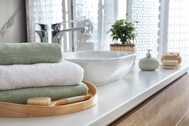 Photo of Towels and brush on table in bathroom. Space for text