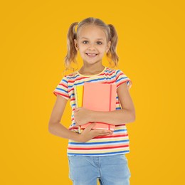 Little child with school supplies on yellow background