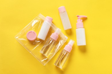 Plastic bag with cosmetic travel kit on yellow background, flat lay. Bath accessories