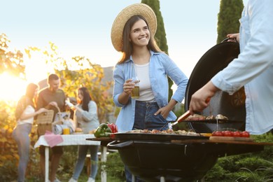Photo of Group of friends having barbecue party outdoors. Space for text