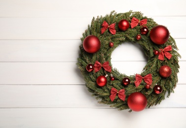 Photo of Beautiful Christmas wreath on white wooden background, top view. Space for text