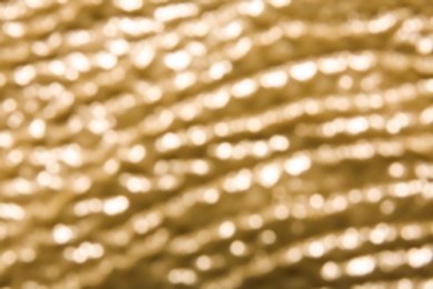 Photo of Blurred view of shiny golden surface as background