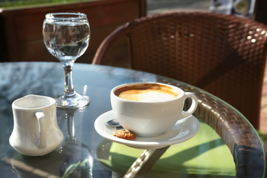 Photo of Cup of fresh aromatic coffee at table in cafe