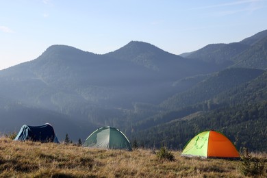 Photo of Picturesque mountain landscape with camping tents in morning