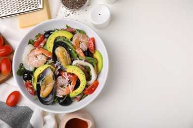 Photo of Bowl of delicious salad with seafood on white table, flat lay. Space for text