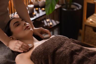 Spa therapy. Beautiful young woman lying on table during massage in salon