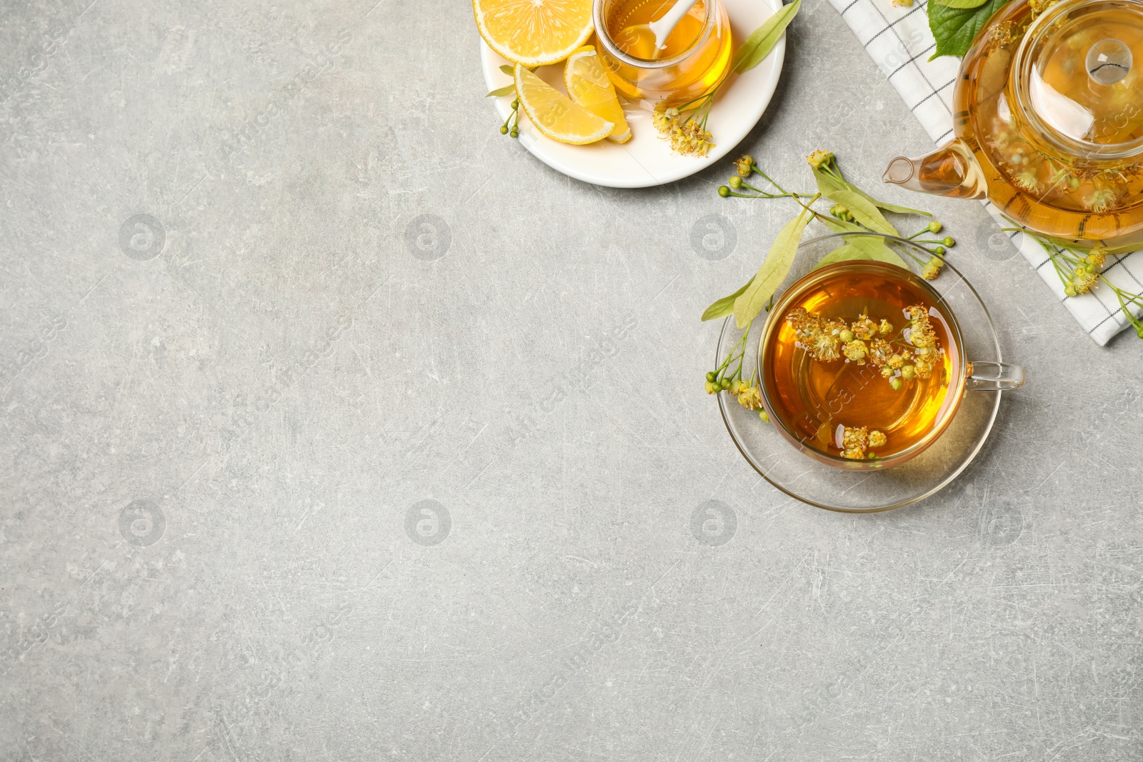 Photo of Flat lay composition with tasty tea and linden blossom on light grey table. Space for text